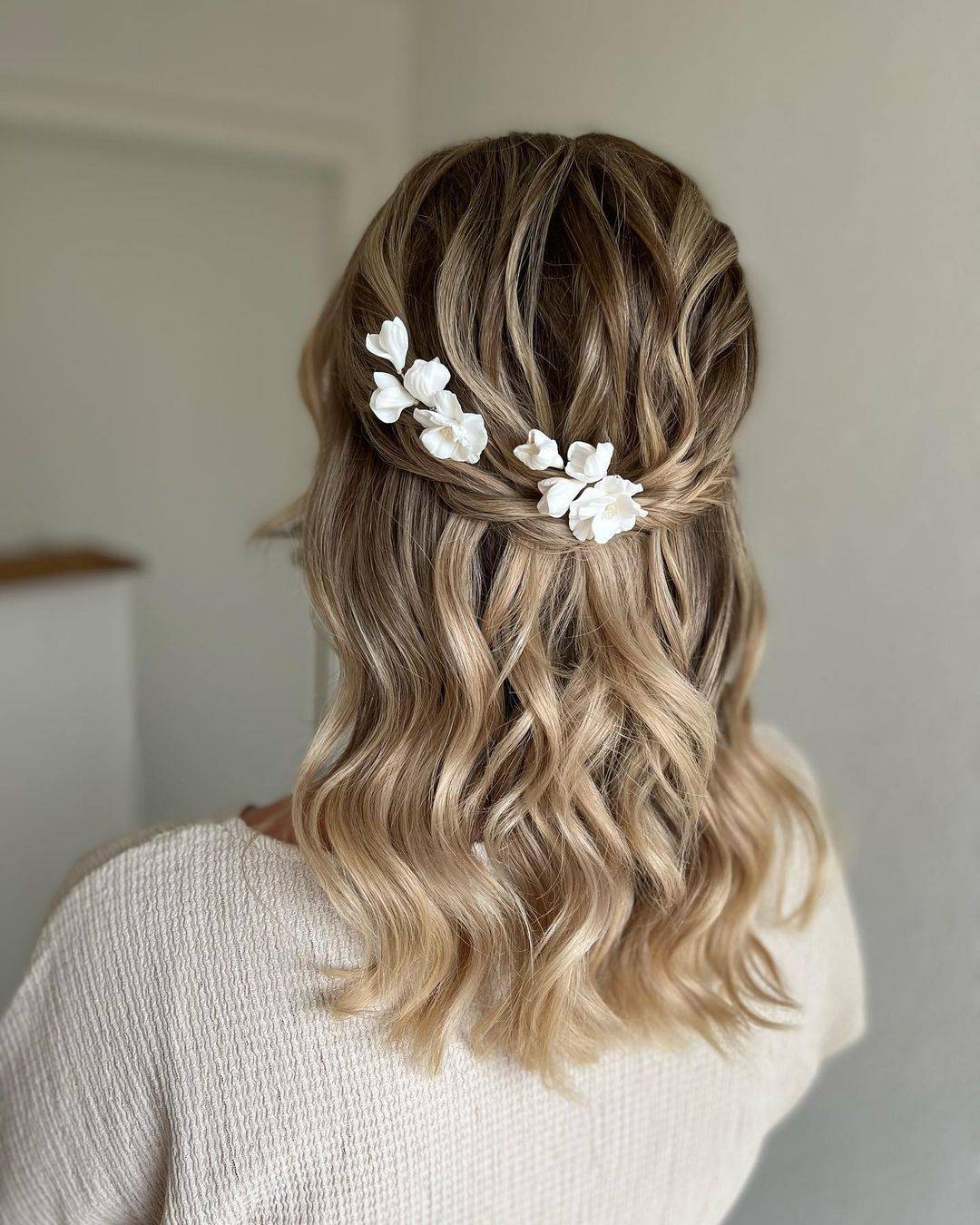 medium-length half up half down bridal hairstyle with flowers