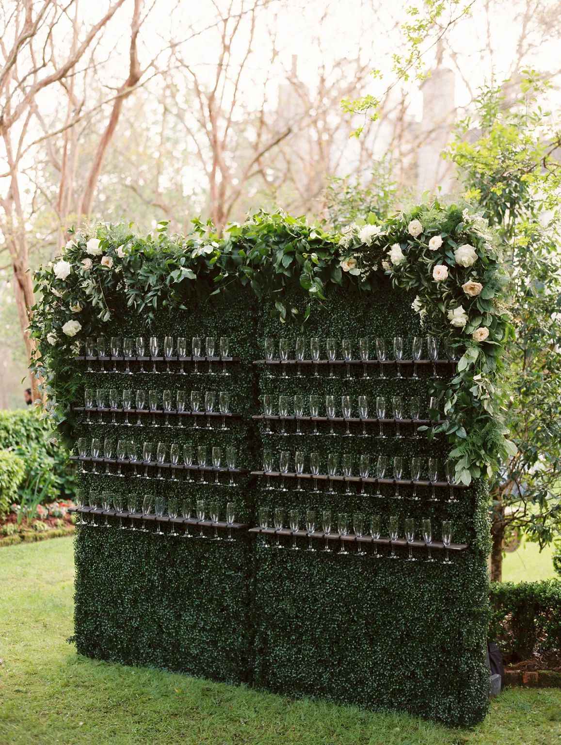 champagne wall with greenery outdoor wedding cocktail hour
