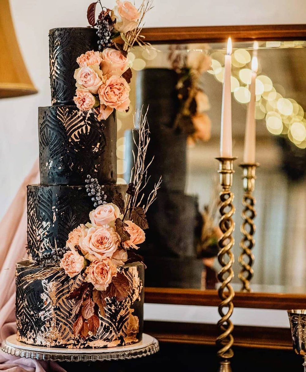 4 tier black wedding cake with rose gold flowers