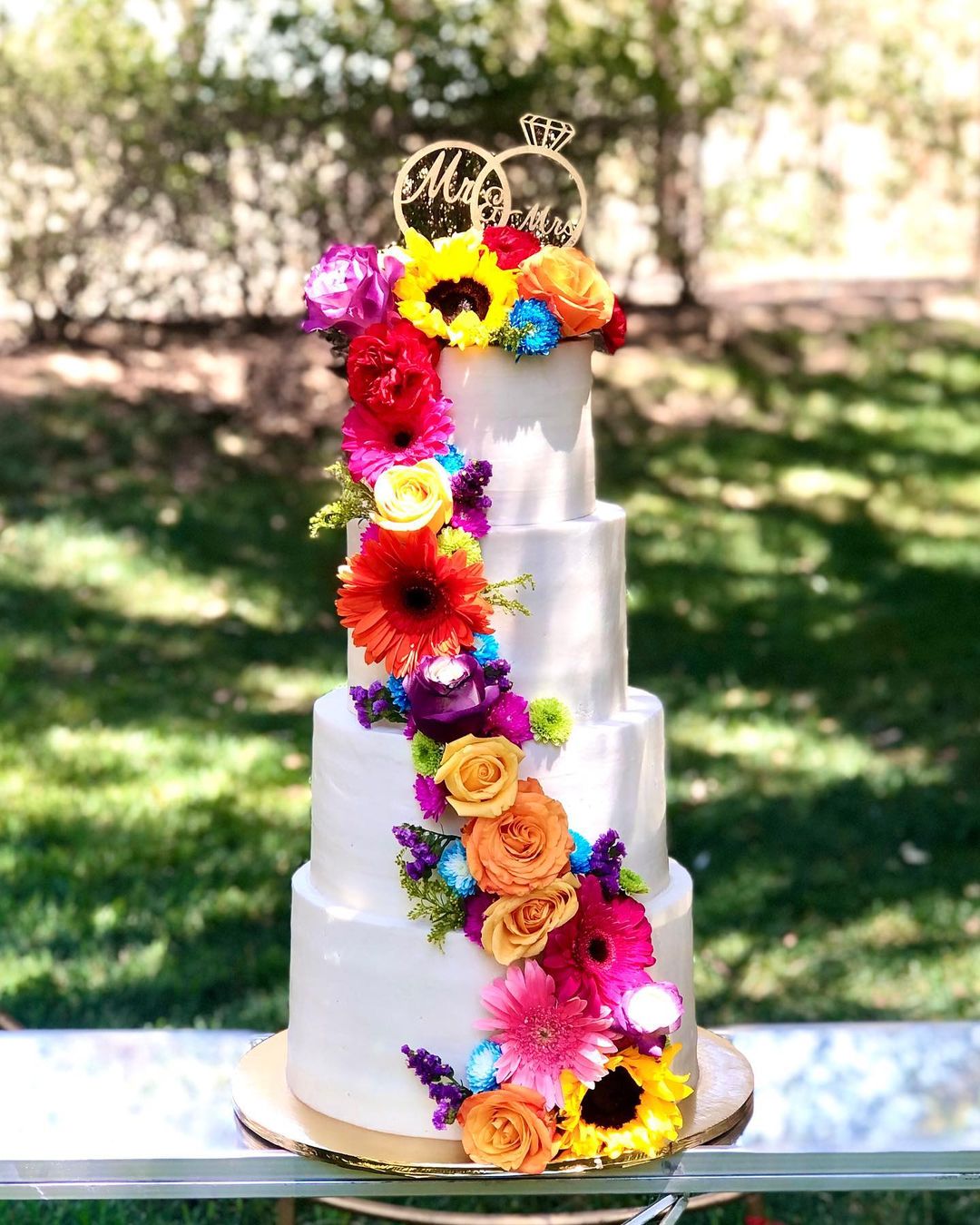 4 tier weddinng cake with colorful flowers mexican style wedding cake via postrecitomio2022