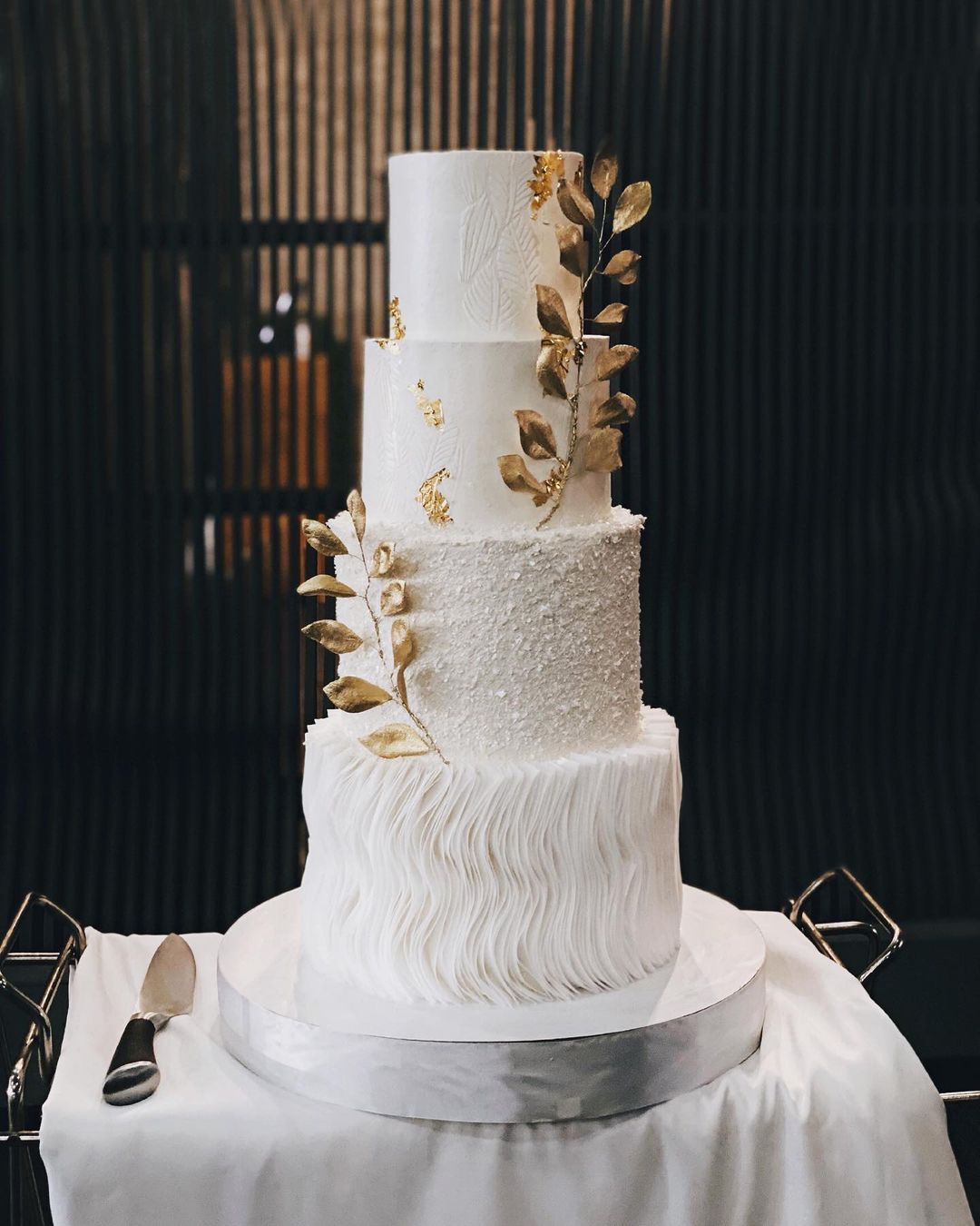 4 tier white and gold wedding cake with gold flakes via victoria__desserts