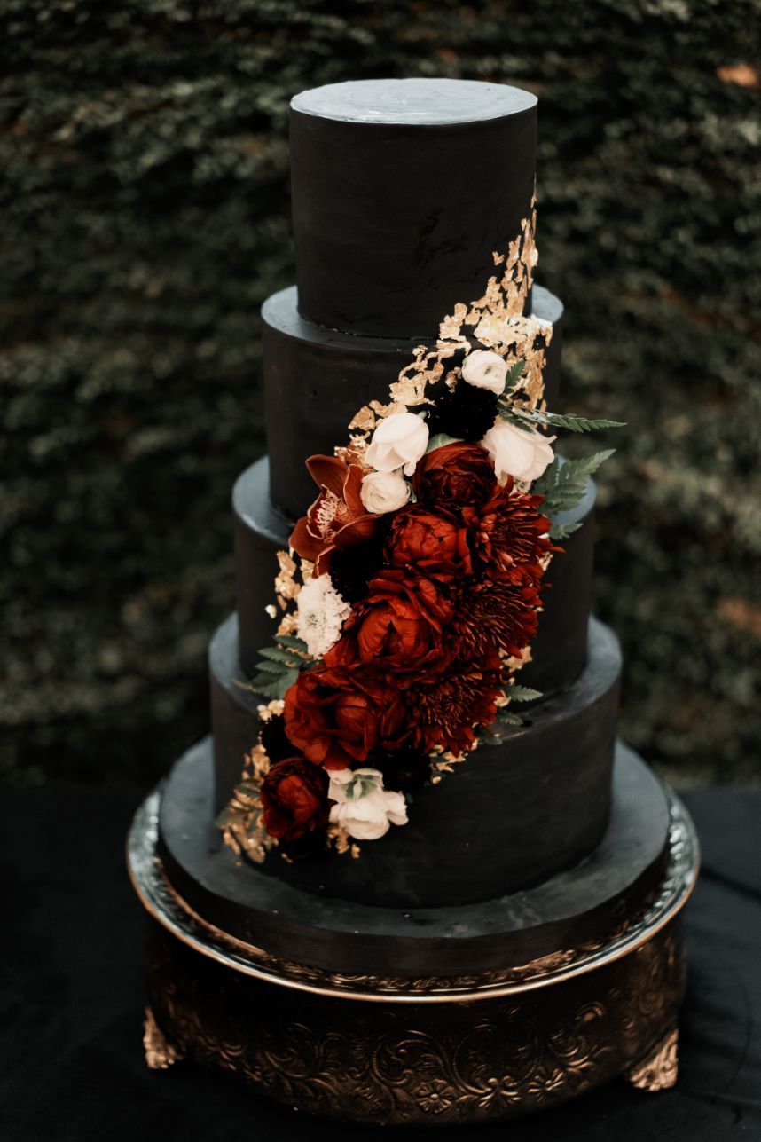 black 4 tier wedding cake with gold accent and burgundy flowers