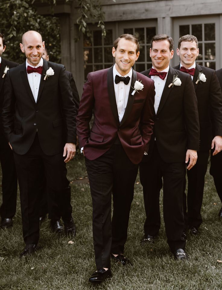 groom in burgundy suit and groommen in black suits
