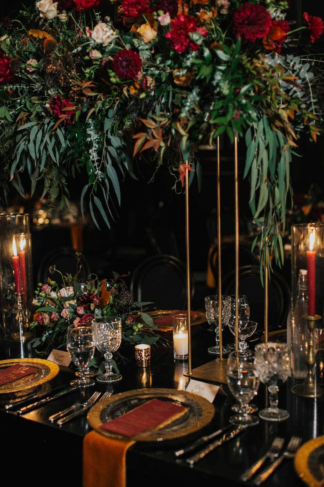 modern black and burgundy wedding table with tall greenery and burgundy flowers
