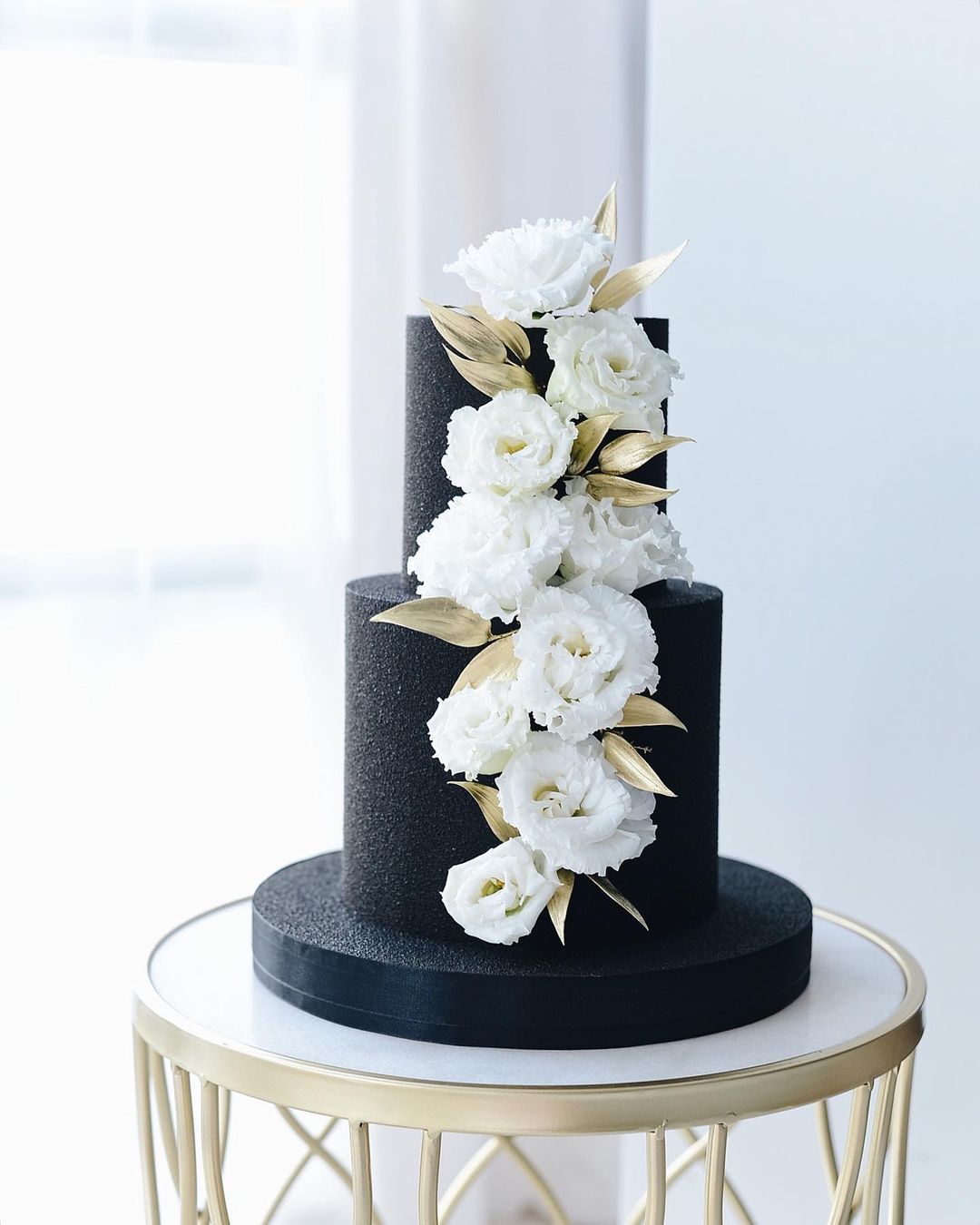 modern black matte textured frosted wedding cake with white flowerrs via boni_bakery