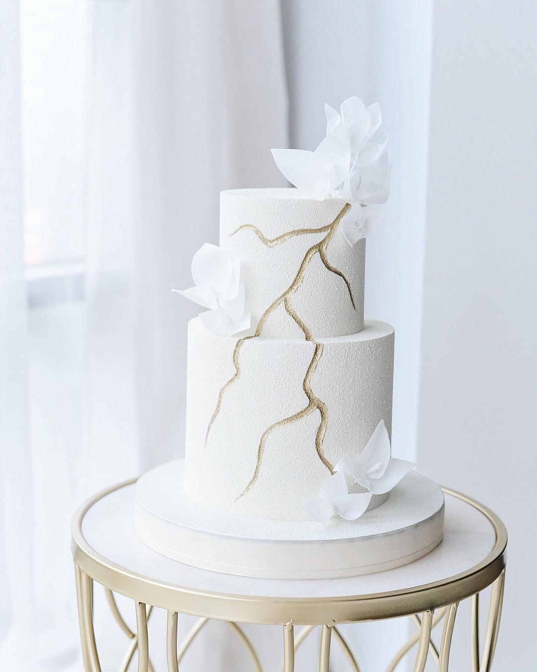 modern white matte textured frosted wedding cake with gold via boni_bakery