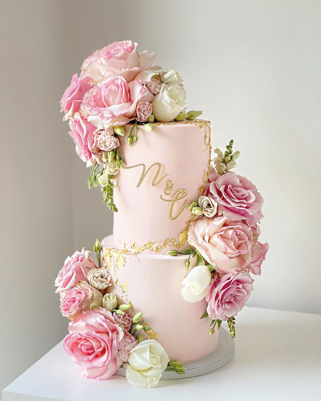 pink and gold wedding cake with pink roses via cakesbylalae