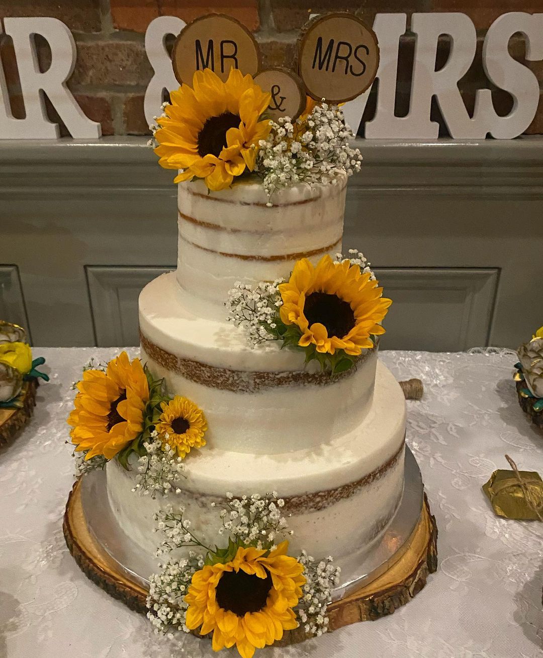 semi-naked three tier wedding cake with sunflowers and wood slice topper cupcakesbynicolle