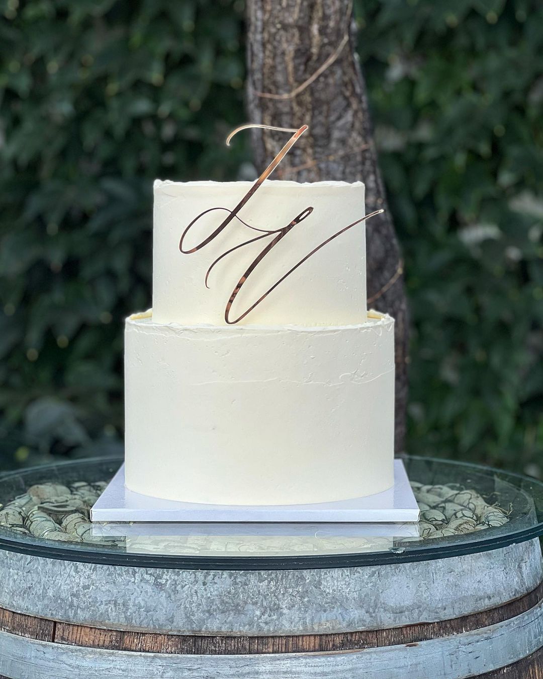 simple 2 tier wedding cake with laser cut rose gold mirror name sign topper via domcine_laskonky