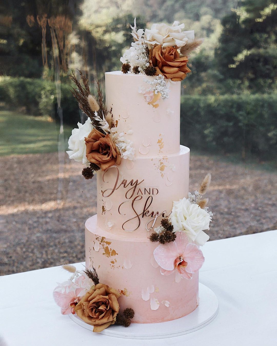 three tier pink ombre pink wedding cake with terracotta flowers via milkandhoney.cakecreative