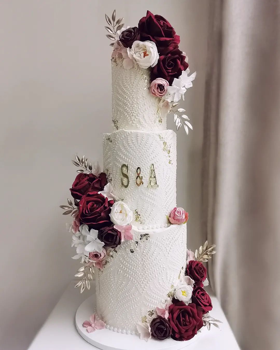 three tier white wedding cake with burgundy flowers via littlemissfattycakes