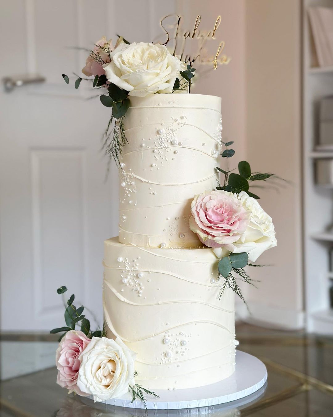two tier buttercream wedding cake with pearls and pink roses via amelias__cakes