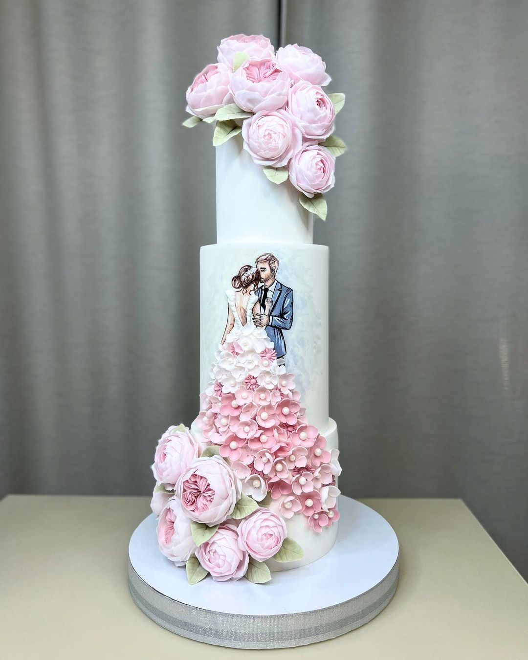 two tier tall wedding cake with pink sugar couple and flowers via kabilova_cake