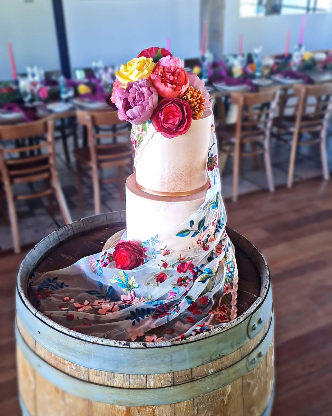 white wedding cake with colorful mexican embroidery fabric via arahvalette_cakeartist