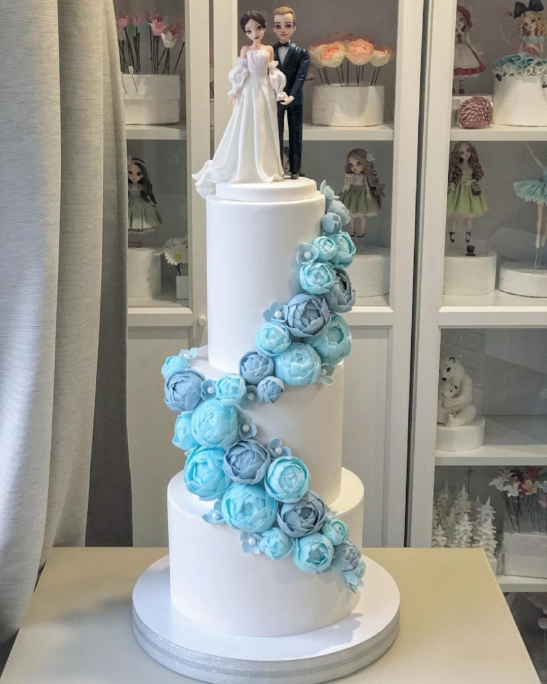 3 tier wedding cake with blue sugar flowers and couple wedding topper via kabilova_cake_205261093_53
