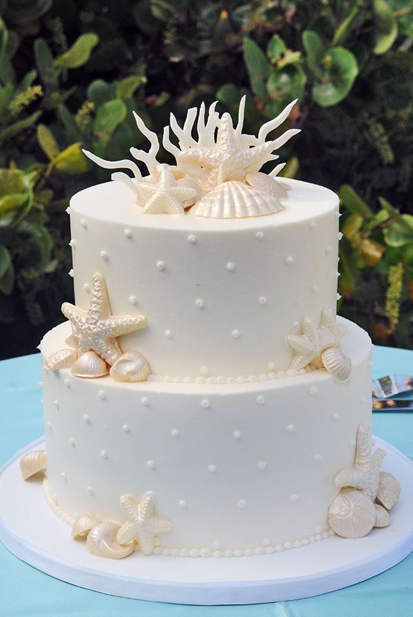 all white beach wedding cake with eatable starfish shell