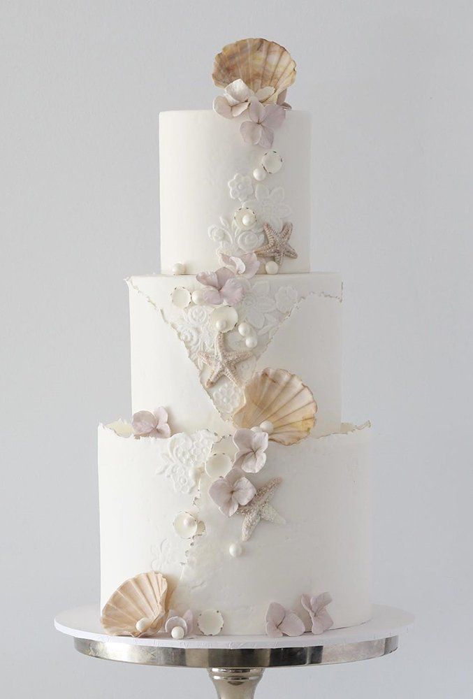 elegant white beach wedding cake with starfish and shell