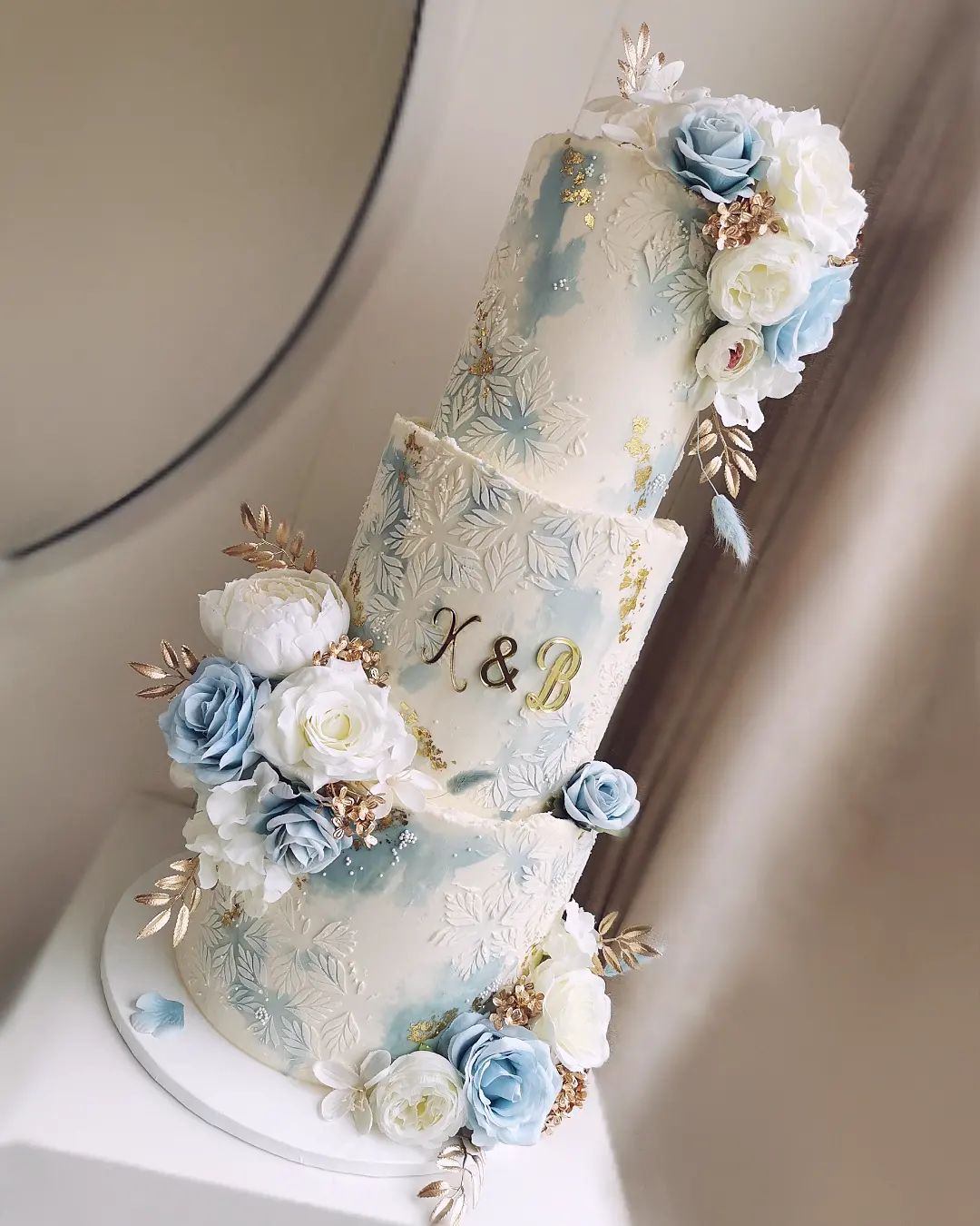 light blue and gold winter wedding cake with fake flowers via littlemissfattycakes
