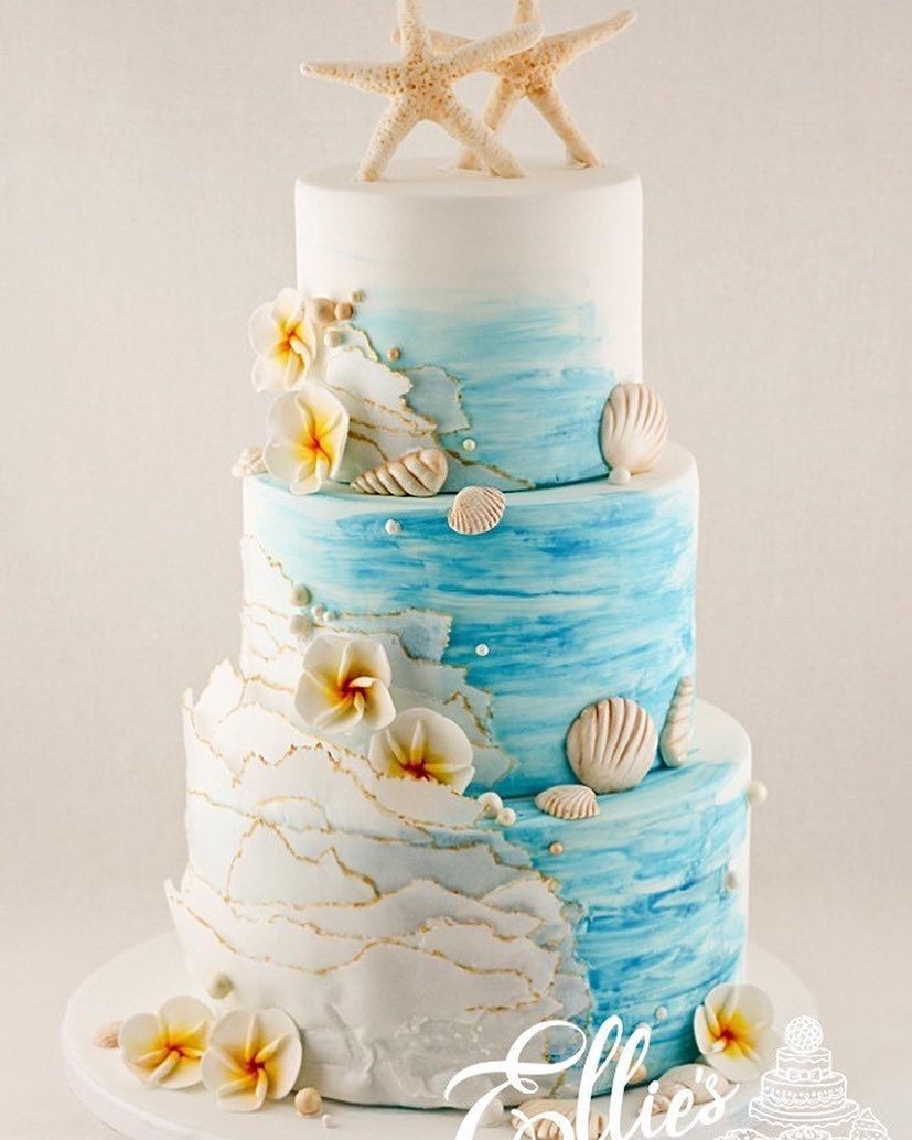 light blue beach wedding cake with frangipani and starfish