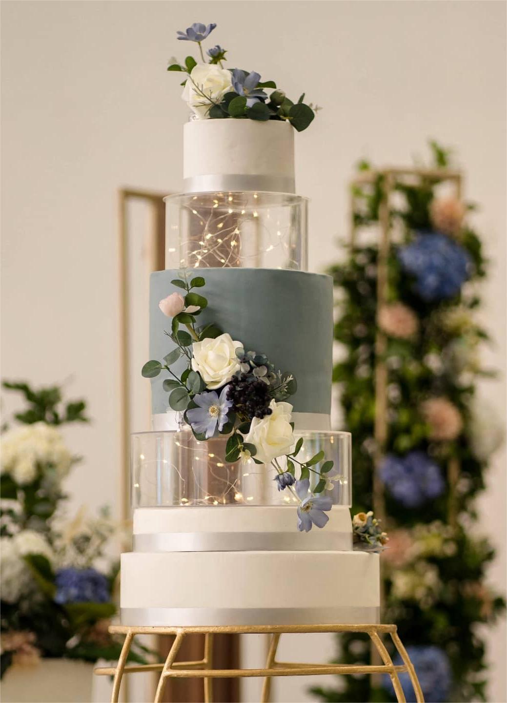 dusty blue wedding cake with acrylic light decorating