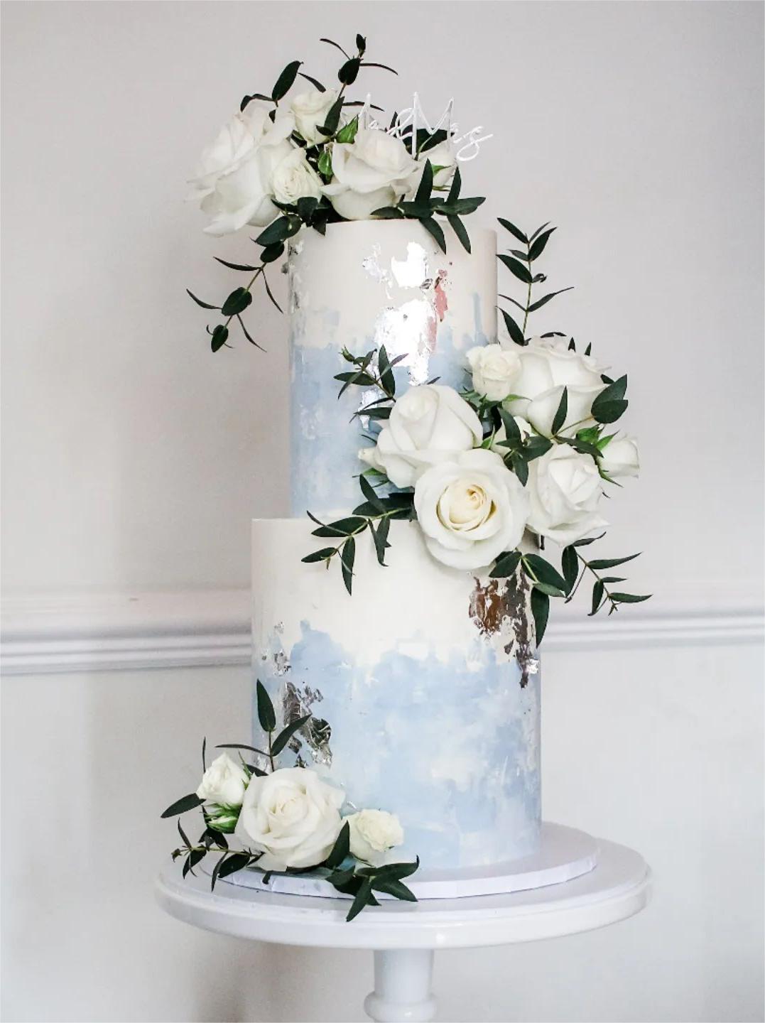 white and light blue wedding cake with white roses via sallycoopercakeartist