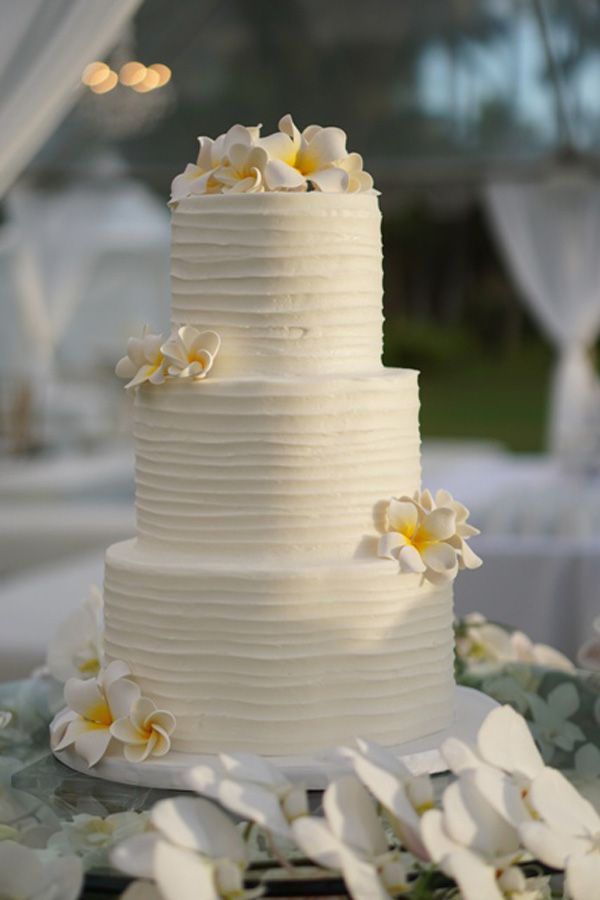 white butter cream beach wedding cake with frangipani