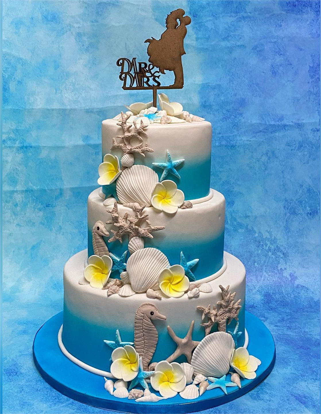yellow frangipani and blue starfish beach wedding cake via cakes.by.nisha