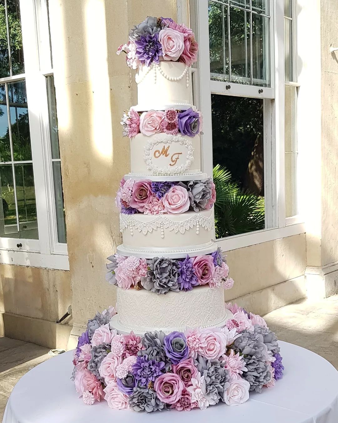 4 tier large vintage wedding cake with purple flowers via cakesbysaminab