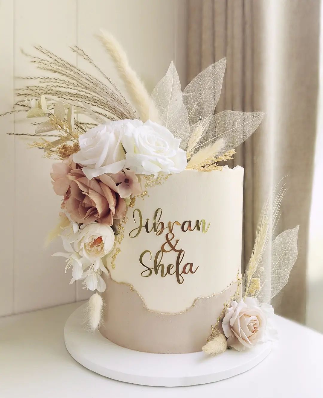 bohemain one tier beige wedding cake with artificial flowers and laser cut mirror names via littlemissfattycakes