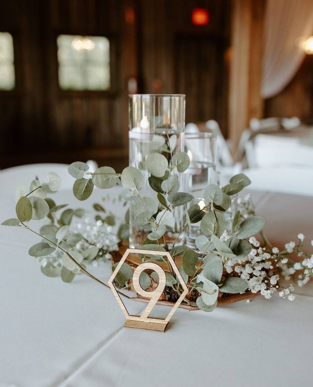 chic eucalyptus and candle wedding centerpiece with baby‘s breath via lovebloomsweddings