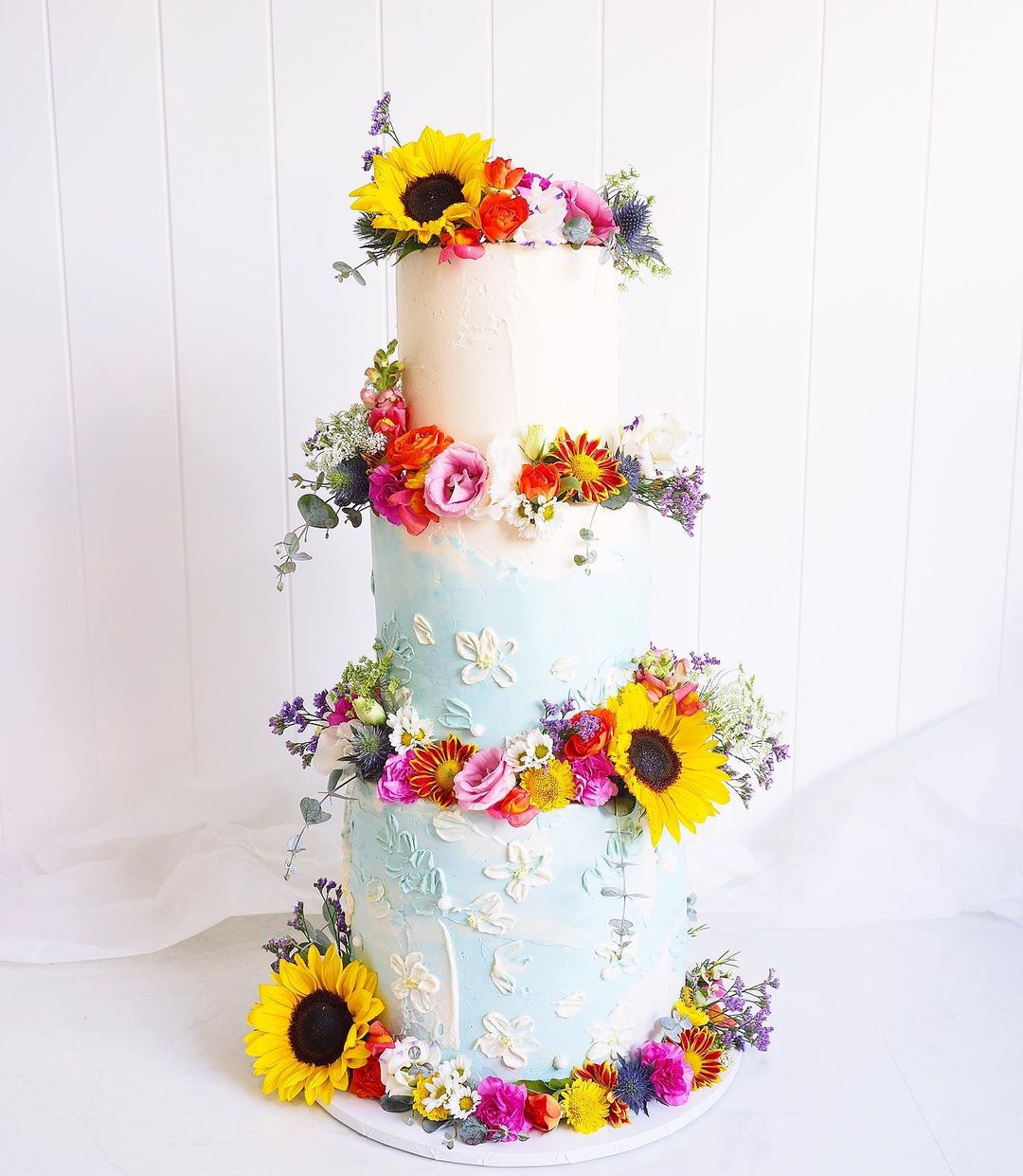 light blue country wedding cake with sunmer flowers via sprinkleandme