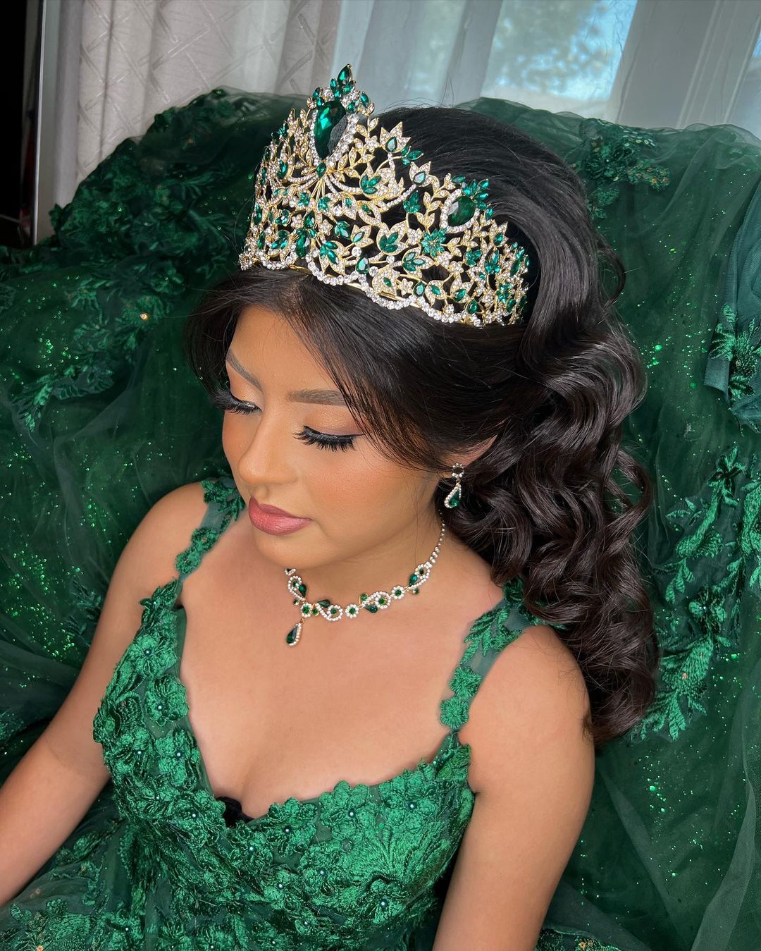 long wavy quinceanera hairstyle with a emerald green crown via veronicatoledomakeup