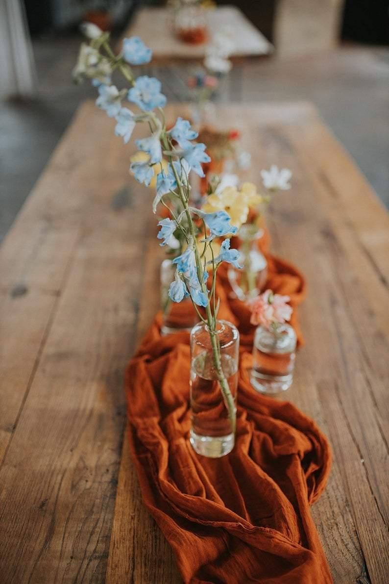 rust double gauze table runner with light blue flowers centerpiece