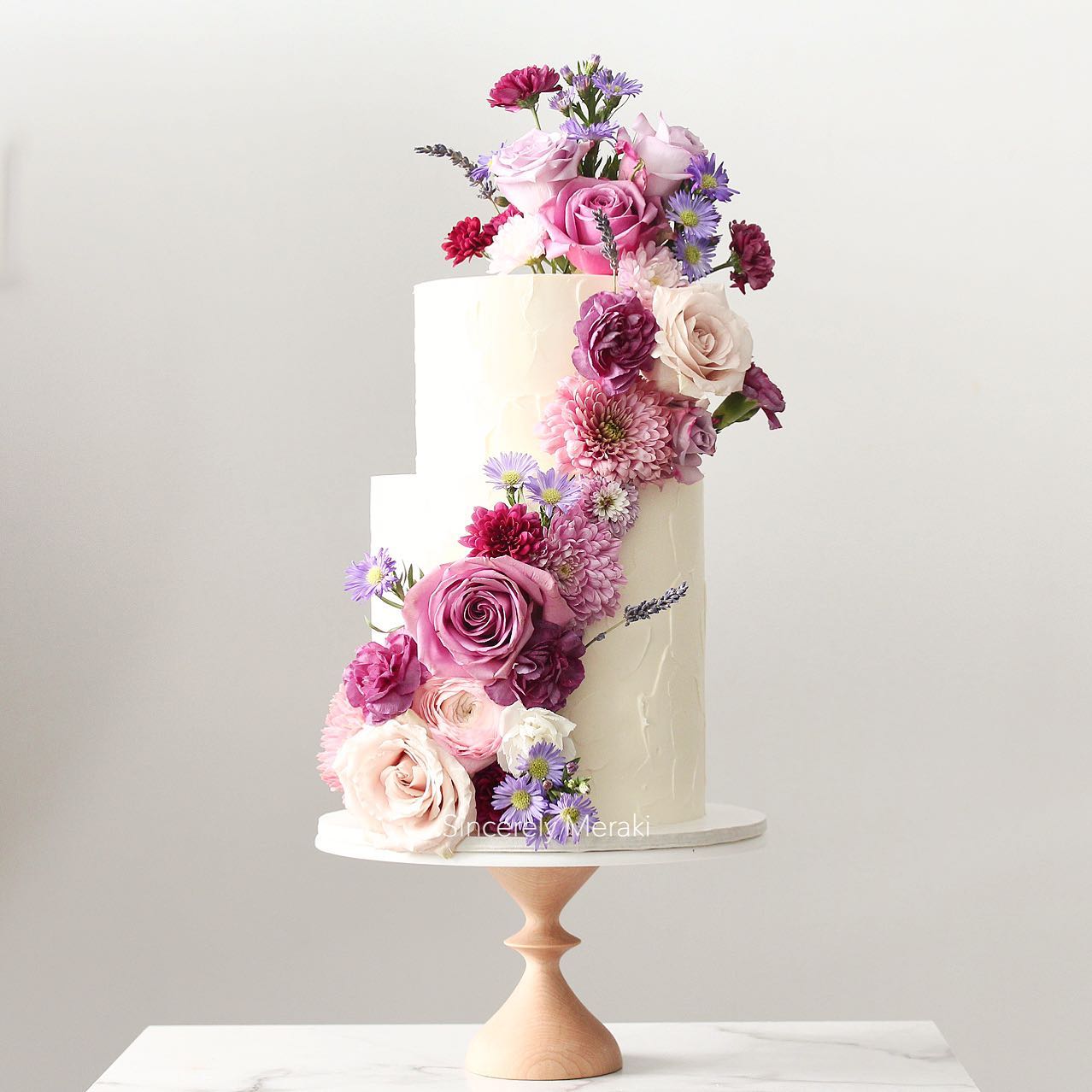 simple 2 tier wedding cake with purple flowers via sincerelymeraki
