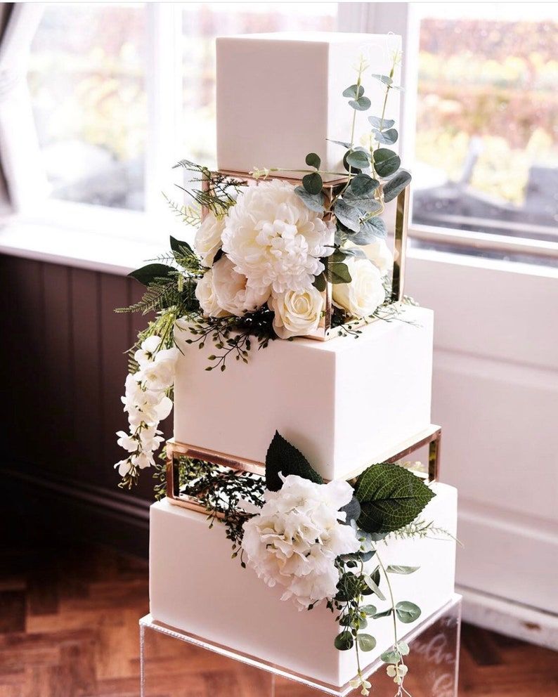 elegant square wedding cake with metallic rectangle cake separator and cake stand