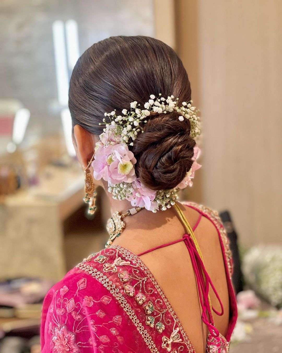gajra bun with pink flowers indian wedding updo via hairbypratiksha