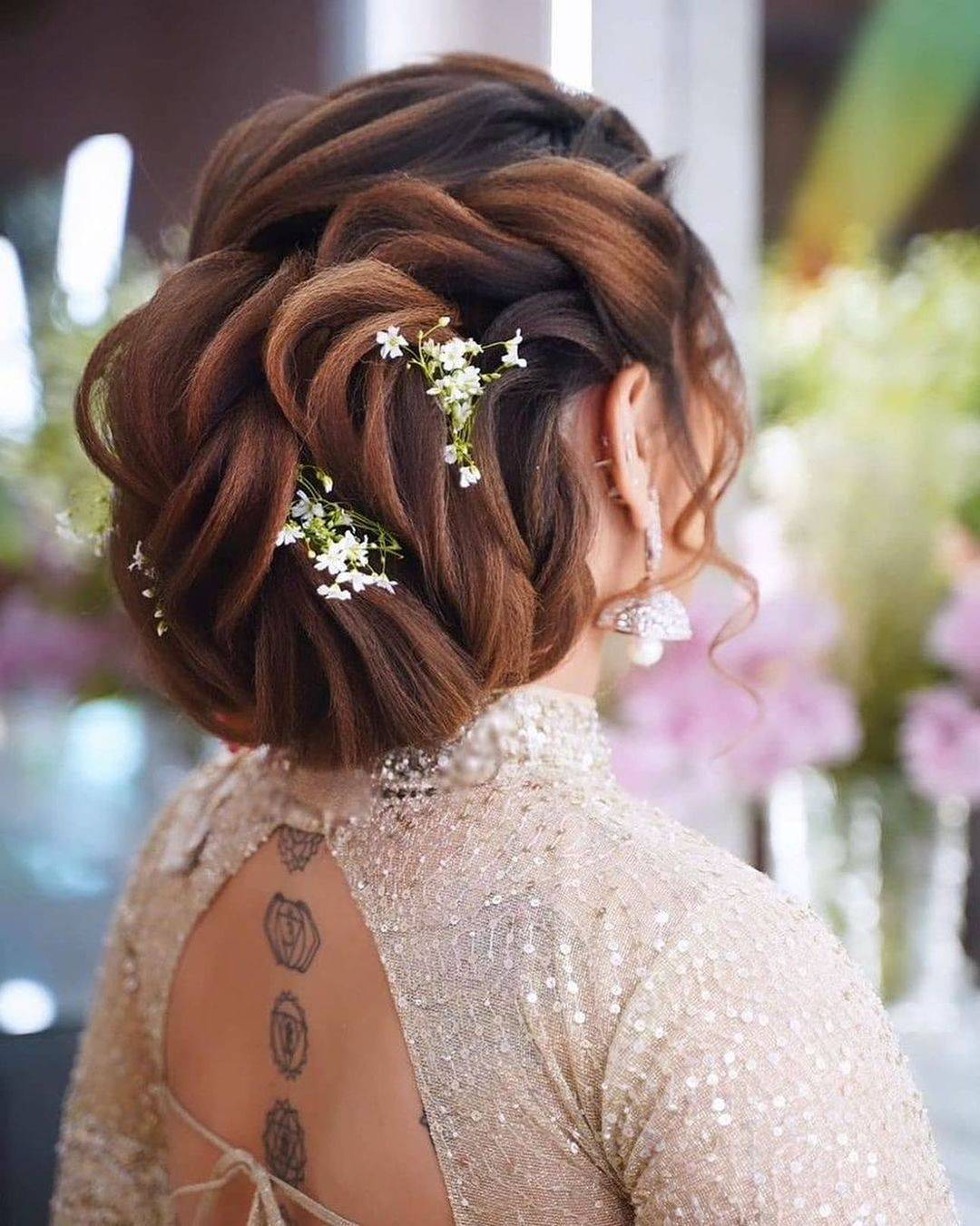 low bun with flowers indian wedding updo via weddingsdecoded