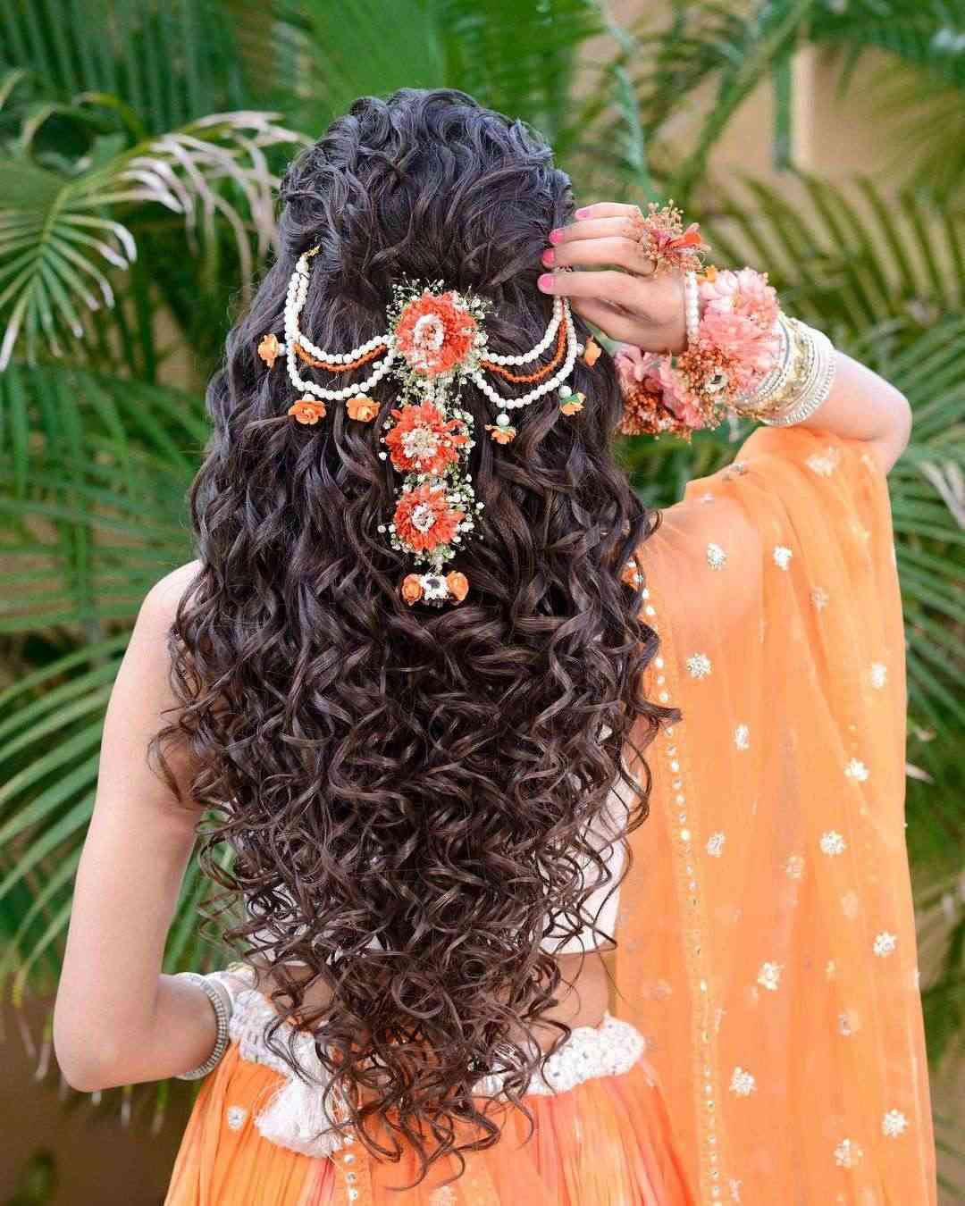 messy curly half up half down indian wedding hairstyle via aayushimakeup