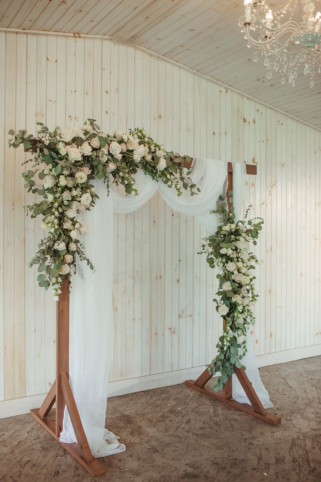 simple wooden greenery and fresh floral wedding arbor