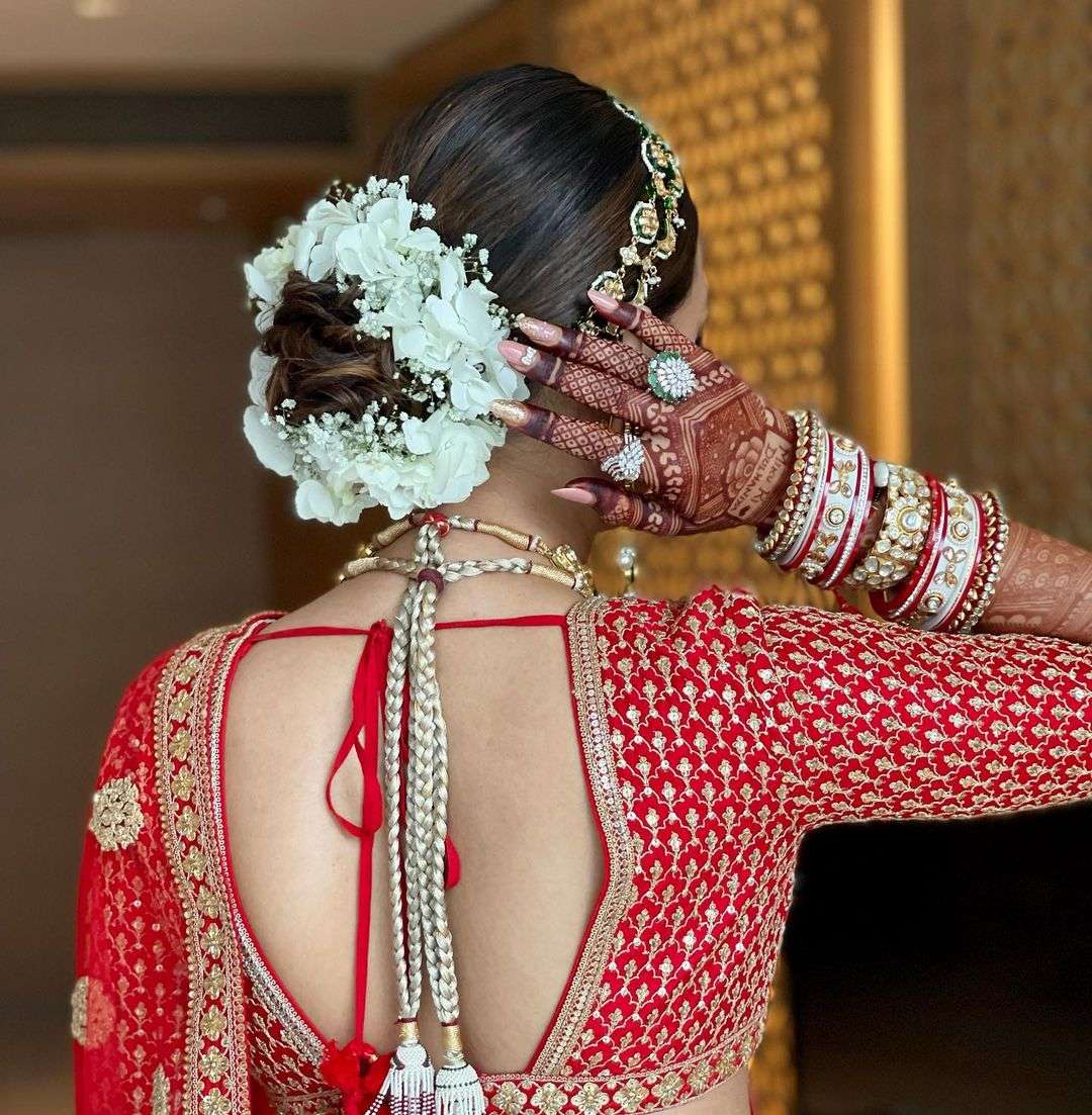 white flower low bun indian wedding hairstyle via hairbypratiksha