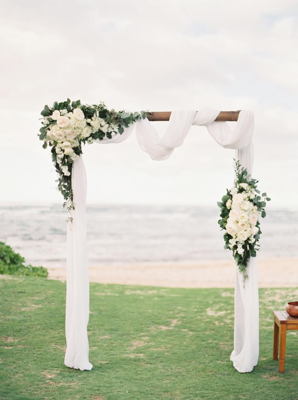 white and greenery hawaiian beach wedding arch