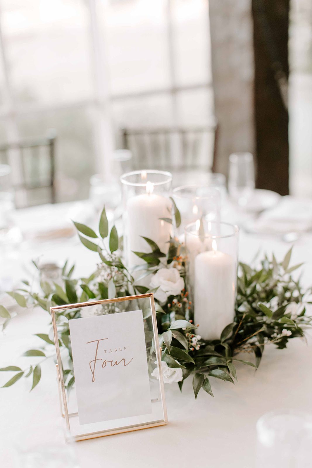 elegant candle and greenery wedding centerpiece