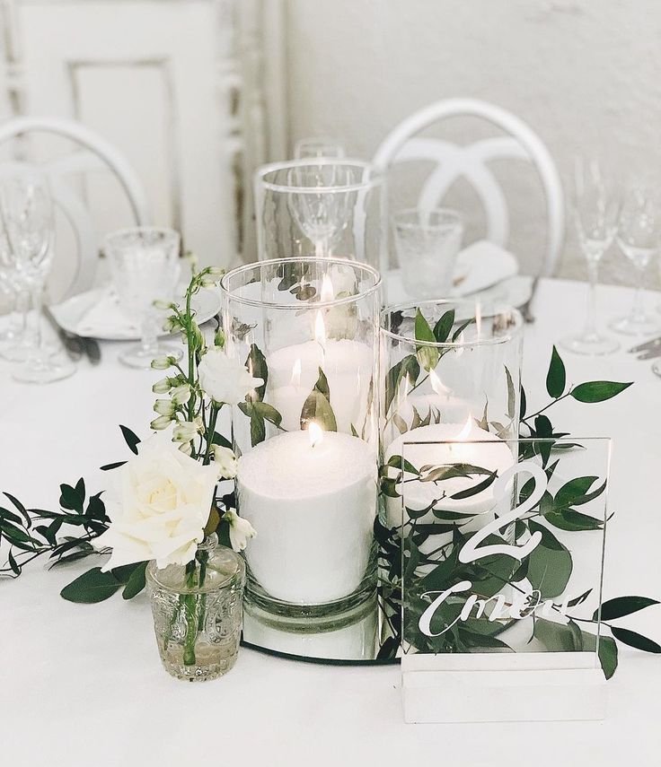 elegant white candles and greenery wedding cengterpieces