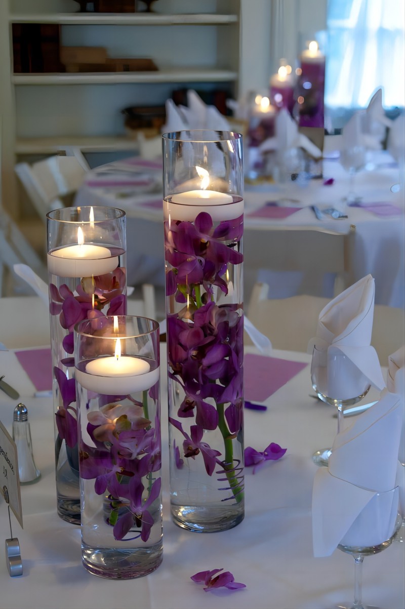 floating candles and purple orchids wedding centerpiece