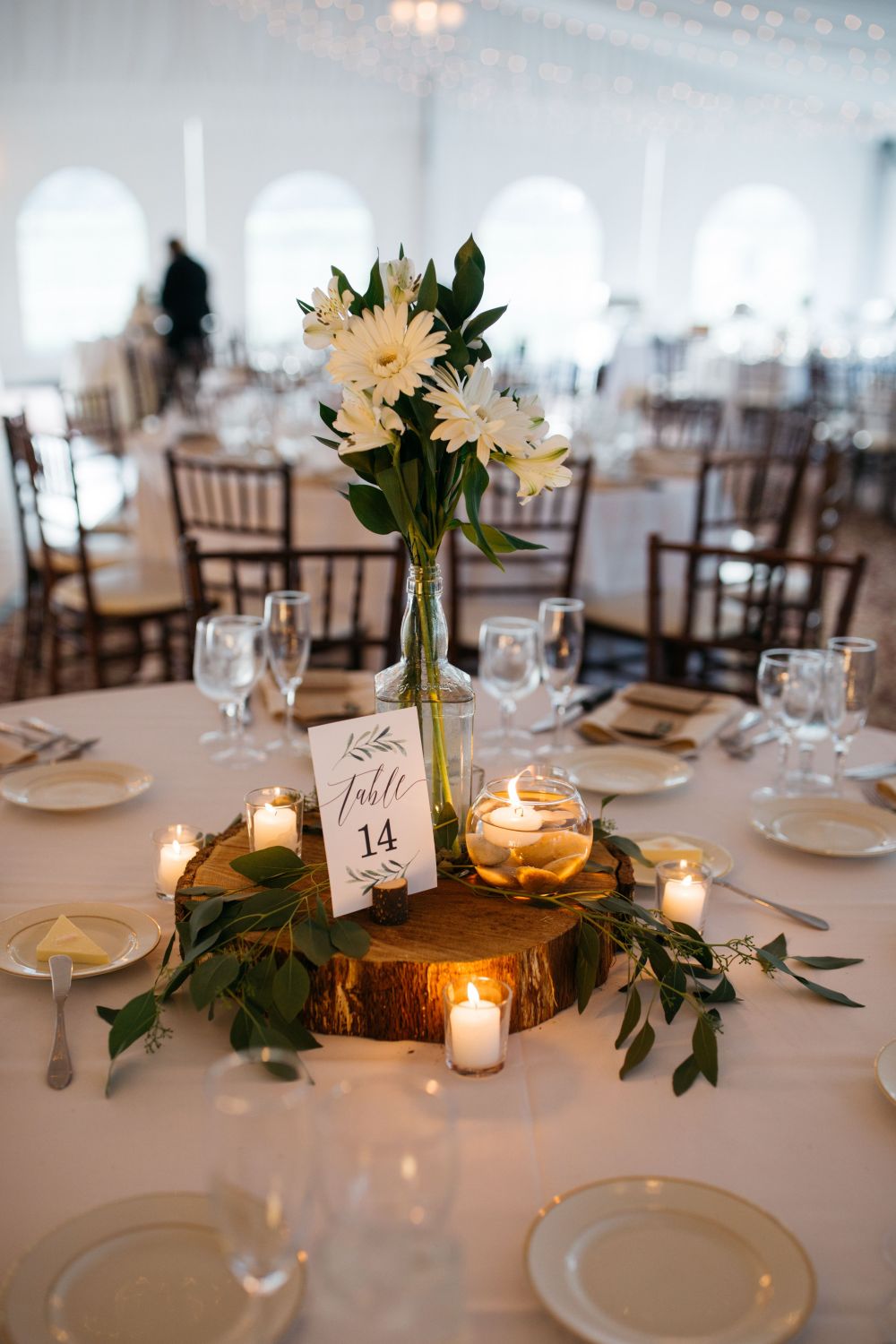 rustic simple white flowers in jar with tree stump wedding centerpiece