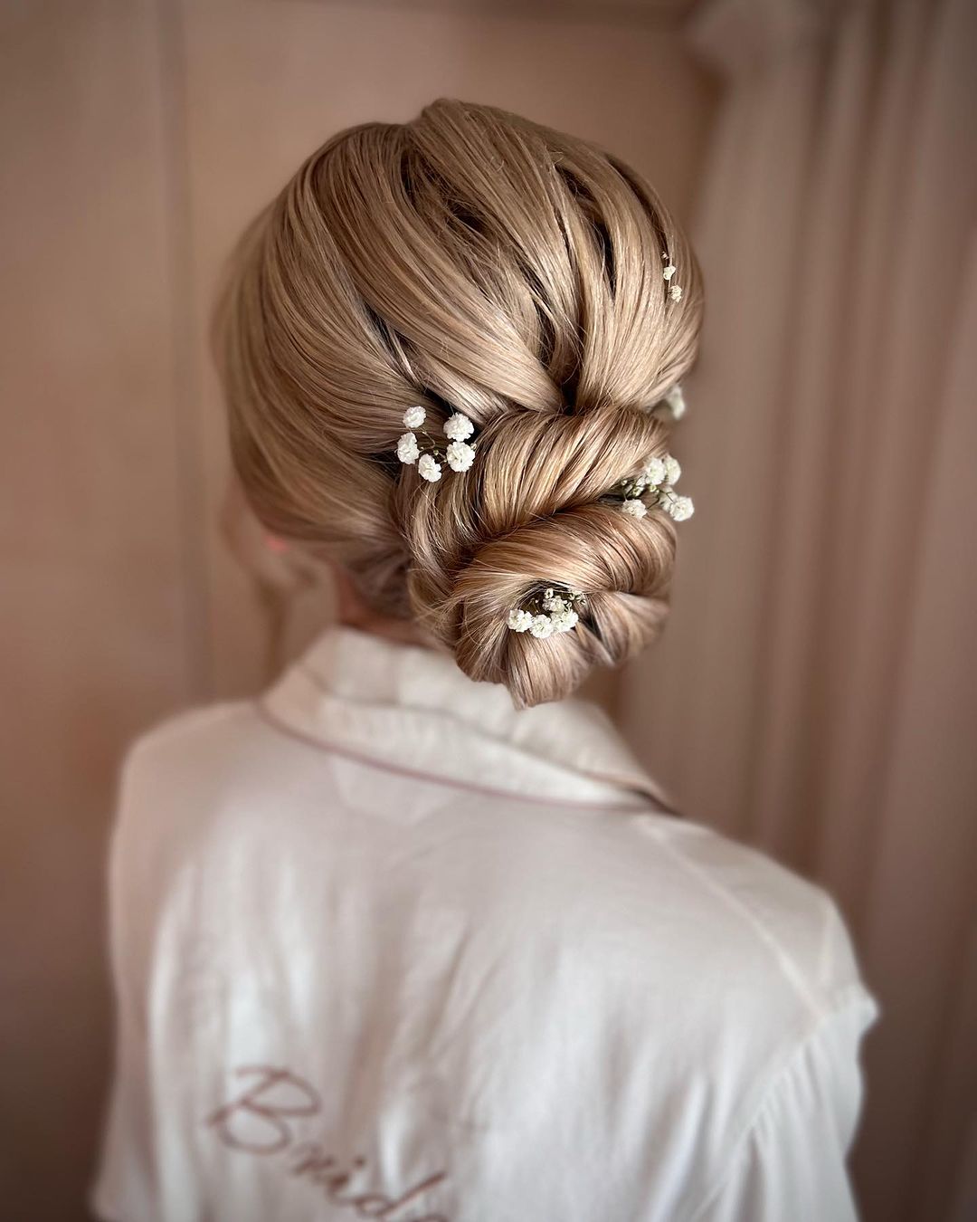 twisted bun hairstyle for wedding with babys breath via lisamariehair